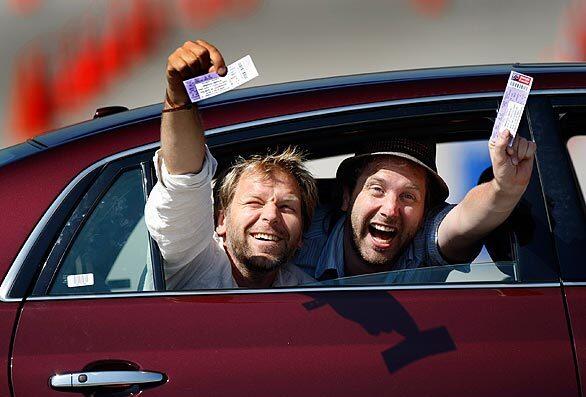 Espen Eckbo, left, and Stein Johan Grieg Halvorsen, from Norway, joyfully wave the Michael Jackson memorial-service tickets they won in an online lottery. They collected their tickets and wristbands at Dodger Stadium.