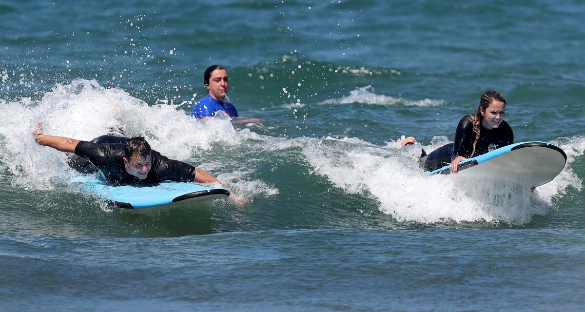 Mr. Irrelevant Brock Purdy, left, and his sister, Whittney, try to catch a wave during surf lessons.