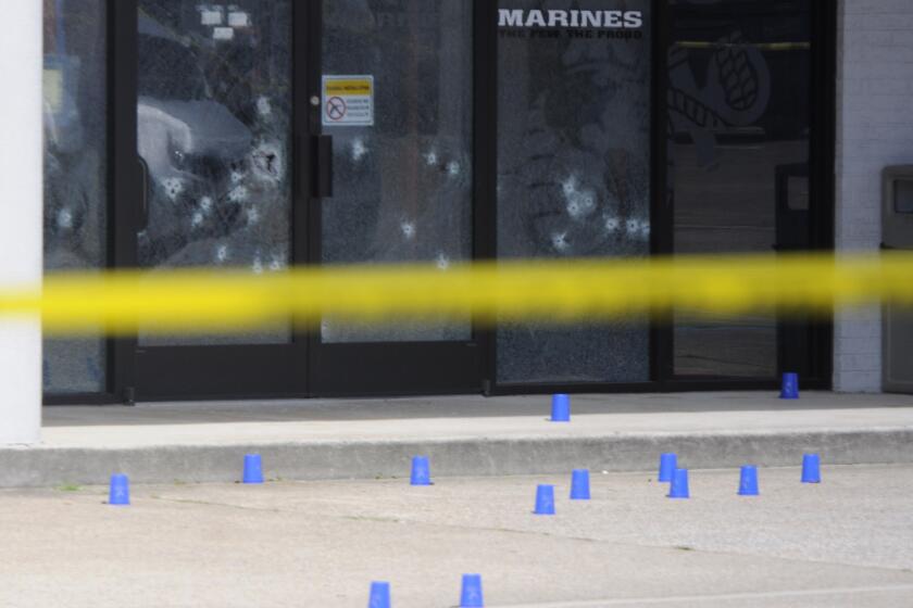 Blue shell-casing markers are scattered outside the military recruiting center, where the attack began.