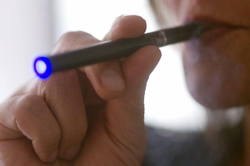 A woman smokes a "Blu" electronic cigarette. A new report from the CDC documents a steep rise in calls to poison control centers related to improper use of e-cigarettes.