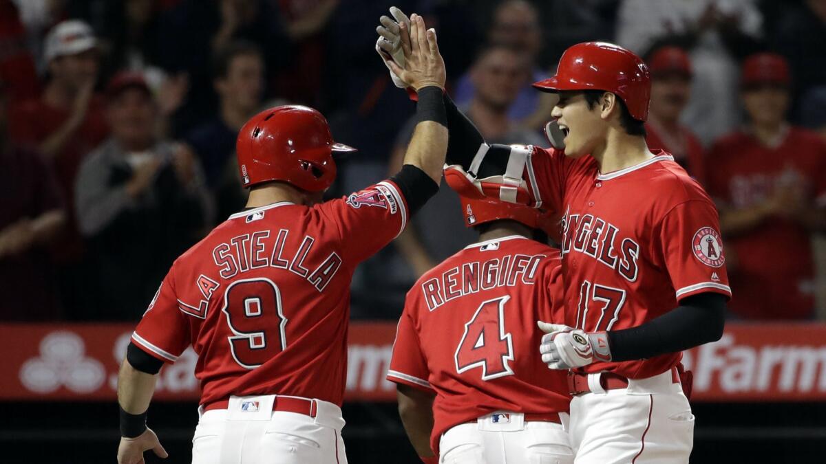The Angels' Shohei Ohtani, right, celebrates his three-run homer with teammate Tommy La Stella (9) during the fourth inning against the Oakland Athletics on June 5 at Angel Stadium.