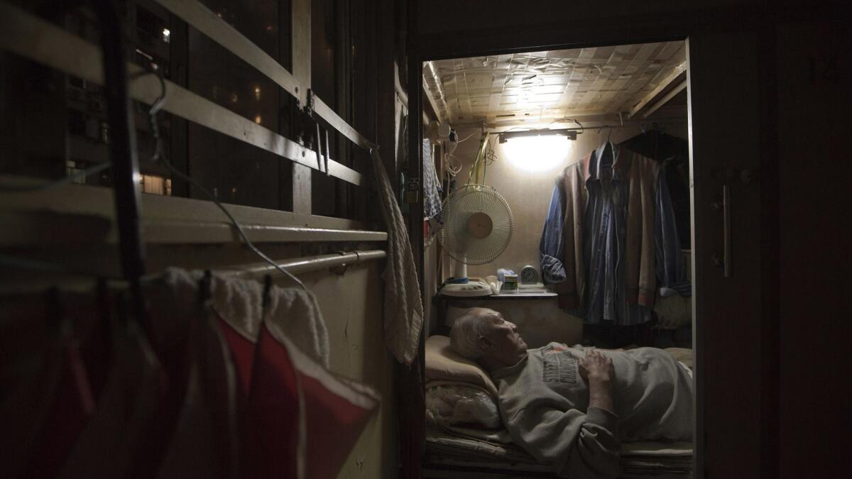 In this March 2017 photo, Tse Chu, a retired waiter, sleeps in his subdivided flat in Hong Kong. In wealthy Hong Kong, there's a dark side to a housing boom, with hundreds of thousands of people forced to live in partitioned shoebox apartments and other inadequate housing.
