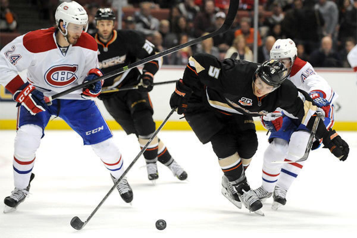 The Ducks' Luca Sbisa battles for the puck with Montreal's Jarred Tinordi, left, and Daniel Briere at the Honda Center last week.