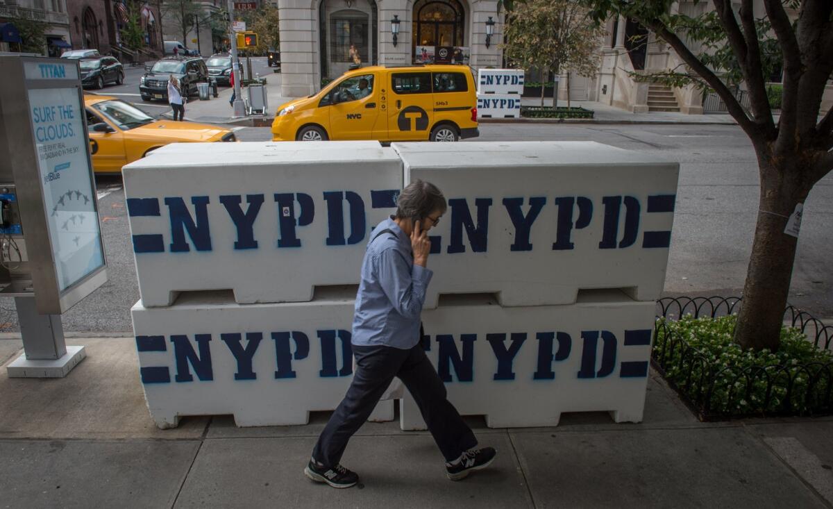 A pedestrian passes NYPD concrete barriers near the residence to the Vatican's ambassador to the United Nations, where Pope Francis is scheduled to stay, Tuesday, Sept. 22, 2015, in New York. (AP Photo/Bryan R. Smith)