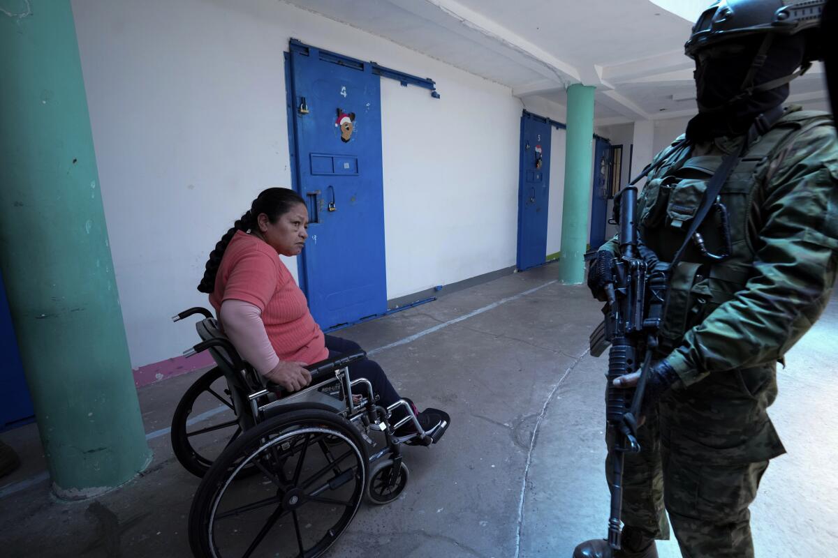 Una mujer presa observa a un soldado que vigila en la cárcel de Cotopaxi durante un recorrido 