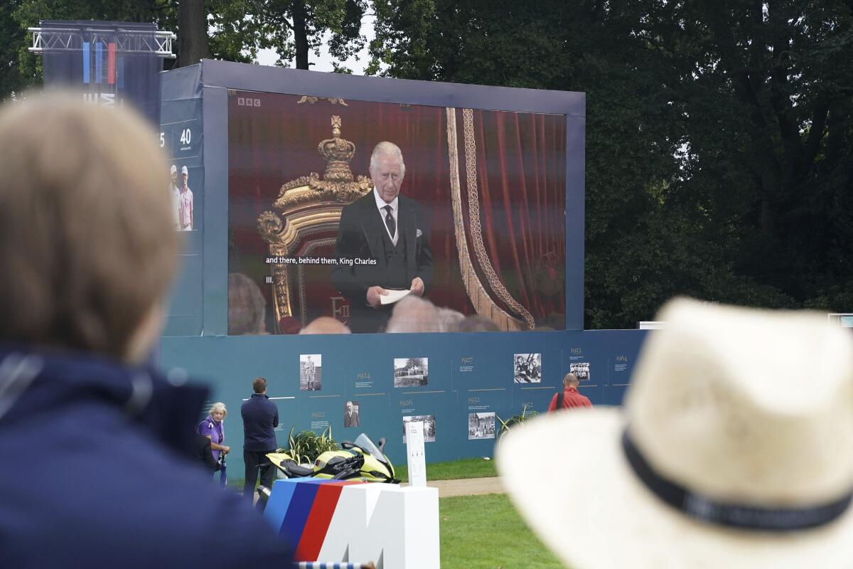 Spectators watch the Accession Council, where King Charles III is formally proclaimed monarch, on the big screen at Wentworth Golf Club, Virginia Water, Britain, Saturday, Sept. 10, 2022. (Adam Davy/PA via AP)