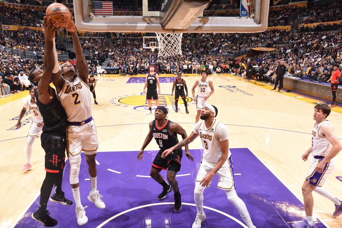 Lakers forward Jarred Vanderbilt (No. 2) grabs a rebound with inside position against a Rockets player.
