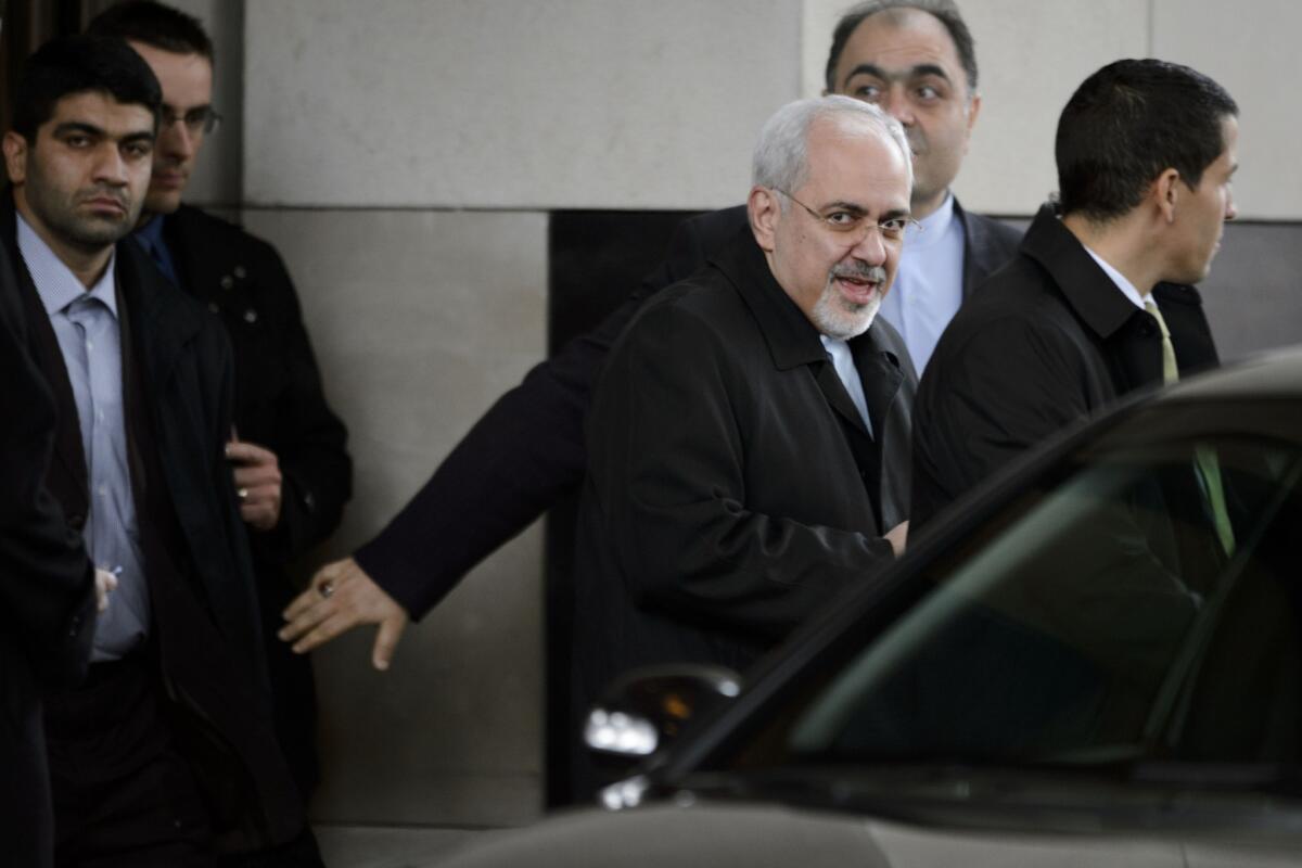 Iranian Foreign Minister Mohammad Javad Zarif, center, leaves a hotel before the start of closed-door nuclear talks in Geneva.