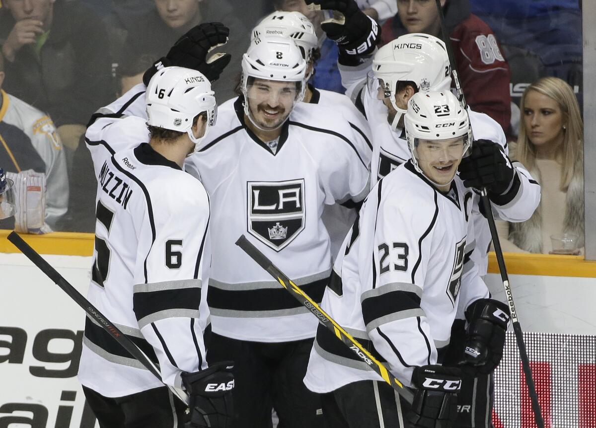 Kings defenseman Drew Doughty, center, celebrates with teammates, including Jake Muzzin (6) and Dustin Brown (23), after scoring against Nashville on Nov. 25.