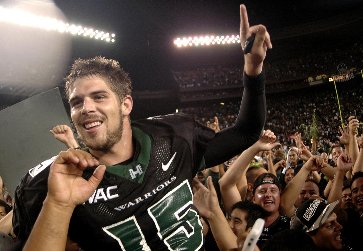 Hawaii quarterback Colt Brennan holds a finger up as he celebrates with the crowd after an NCAA college football game
