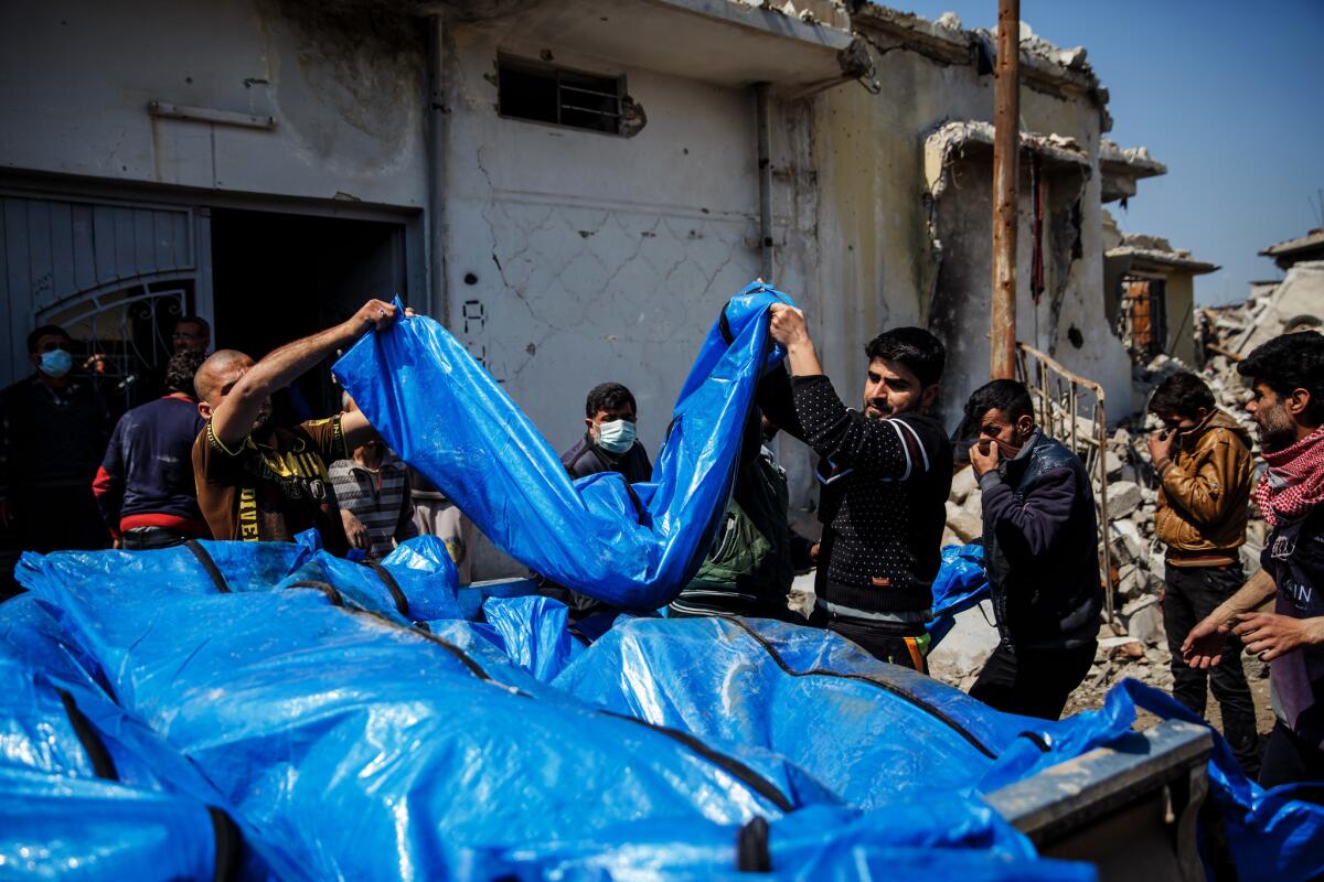 Residents pile body bags in the back of a pickup truck in March after recovering the remains of relatives and neighbors they said were killed by an airstrike in west Mosul’s Jadidah neighborhood.