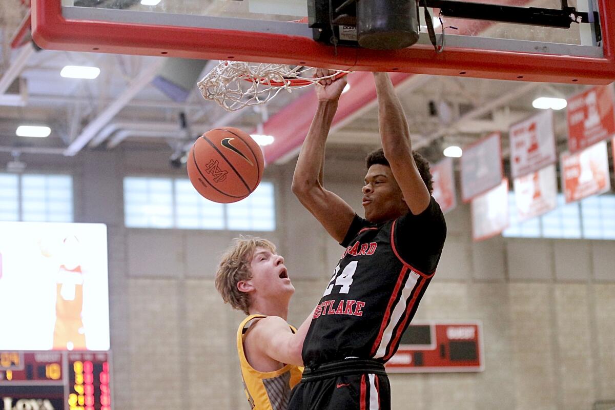 Harvard-Westlake’s Isaiah Carroll dunks over Foothill’s Danny Kennard in the Wolverines’ 74-54 win.
