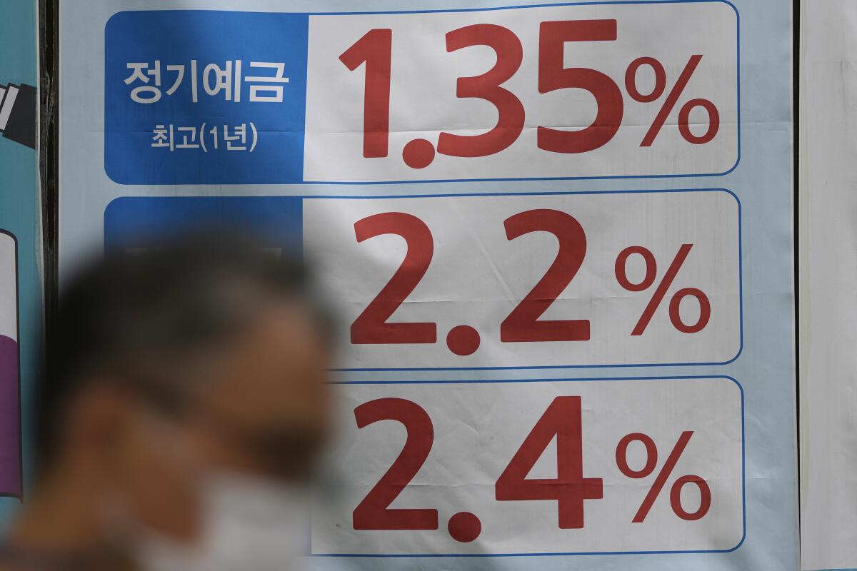 A man walks near an advertisement showing bank's interest rates in downtown Seoul, South Korea, Friday, Sept. 17, 2021. Asian shares were mixed on Friday after a hodge-podge of economic data led Wall Street to close mostly lower. (AP Photo/Lee Jin-man)