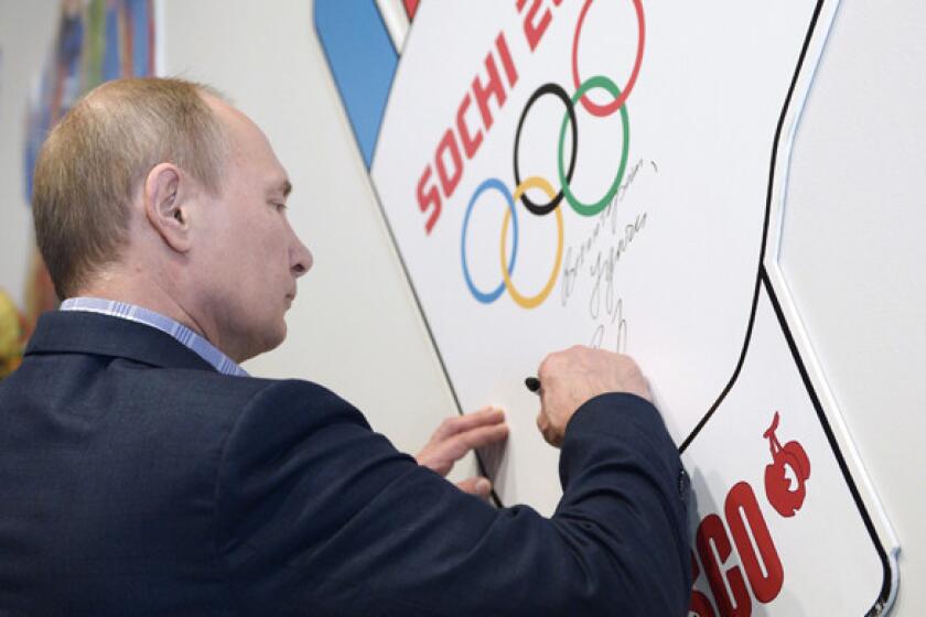 Russian President Vladimir Putin signs his name during a visit to a training center for Winter Olympic Games volunteers in Sochi, Russia, on Saturday. The Black Sea resort city will play host to the 2014 Olympic Games next month.