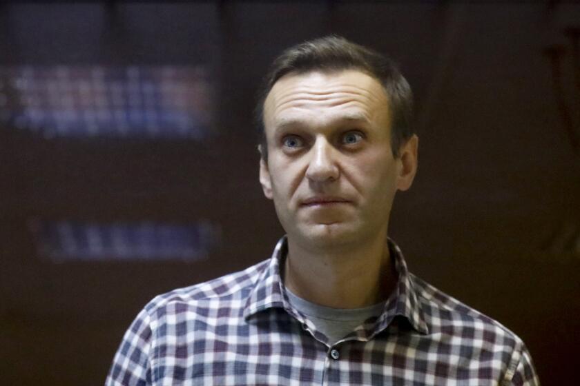 FILE - Russian opposition leader Alexei Navalny stands in a cage in the Babuskinsky District Court in Moscow, Russia on Feb. 20, 2021. Russia's most prominent opposition leader, Alexei Navalny, lost another court battle Wednesday, Oct. 26, 2022, in his effort to push back against the Kremlin's widening crackdown on him and other dissenters. (AP Photo/Alexander Zemlianichenko, File)