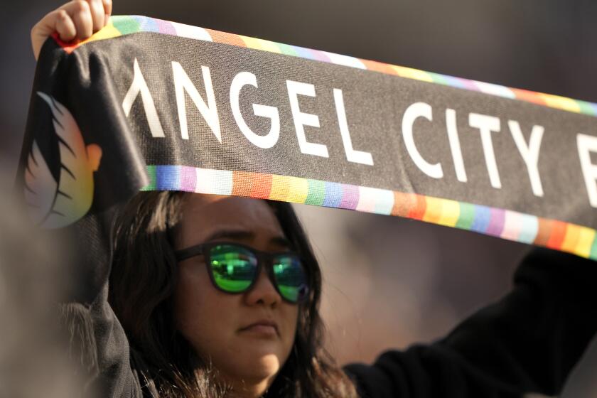 A fan holds up an Angel City scarf as Bay FC takes on Angel City FC during an NWSL soccer match, Sunday, March 17, 2024, in Los Angeles. Bay FC won the match 1-0. (AP Photo/Doug Benc)
