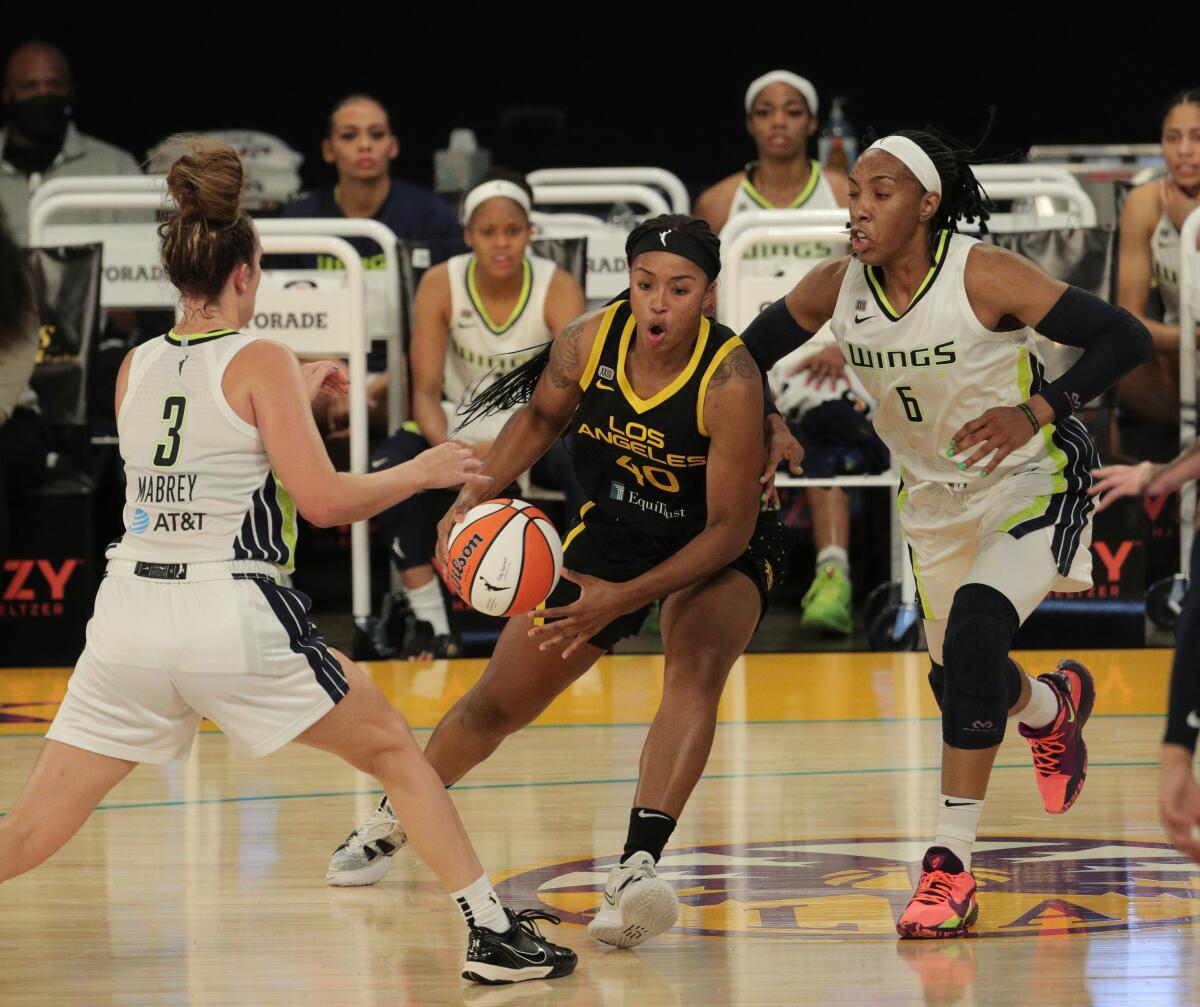 Sparks forward Jasmine Walker handles the ball as the Wings' Marina Mabrey (3) and Kayla Thornton defend.