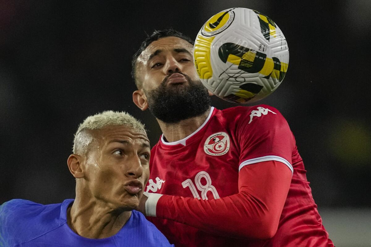 El brasileño Richarlison disputa un balón con el tunecino Ghaylen Chaaleli, 