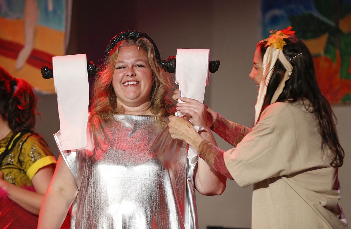 Cast member Ella Wyatt, wearing a tissue paper hat, shares a laugh during a rehearsal for Lagunatics.