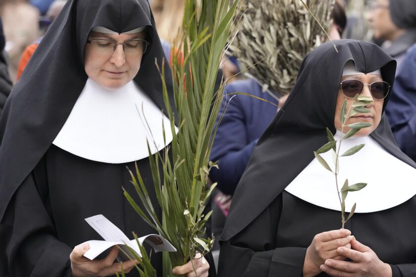 FILE - Nuns wait for the start of the Palm Sunday's mass celebrate by pope Francis in St. Peter's Square at The Vatican Sunday, April 2, 2023. Palm Sunday will be celebrated by Christians worldwide Sunday, March 24, 2024. It commemorates the Christian belief in the triumphant entry of Jesus into Jerusalem, when palm branches were strewn before him. It marks the start of Holy Week. (AP Photo/Andrew Medichini)