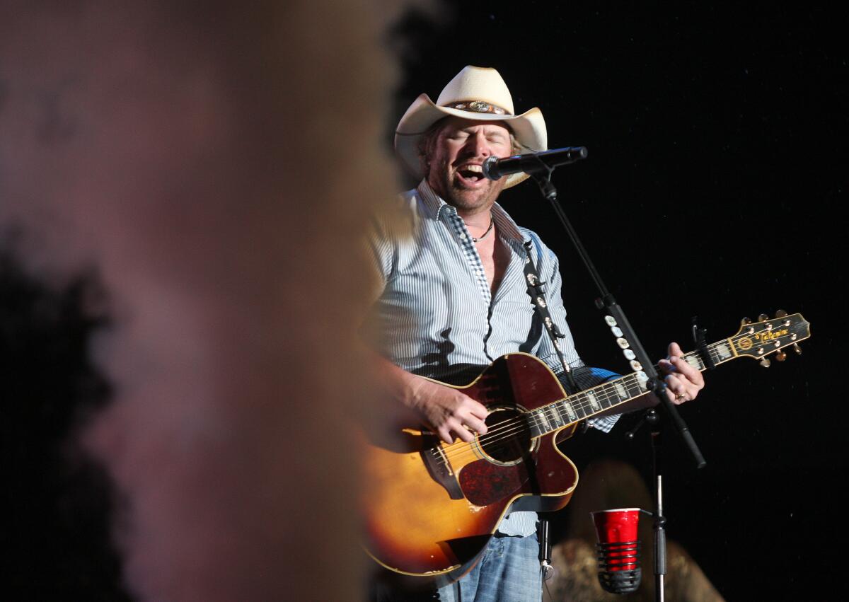 Country singer Toby Keith, shown performing in 2013 at the Stagecoach Country Music Festival, is subject of a bogus Internet report that he would donate proceeds from a new single to help resettlement efforts for Syrian refugees.