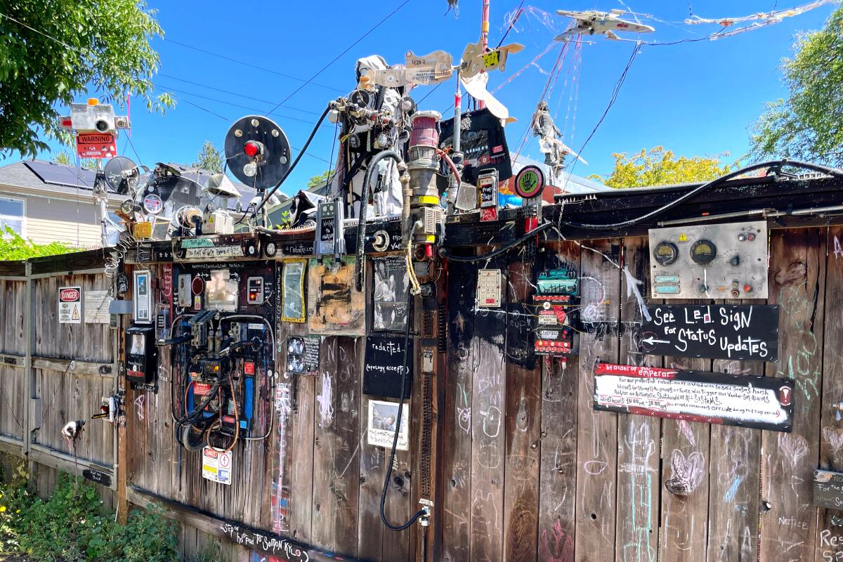 A backyard fence with various displays and gadgets.