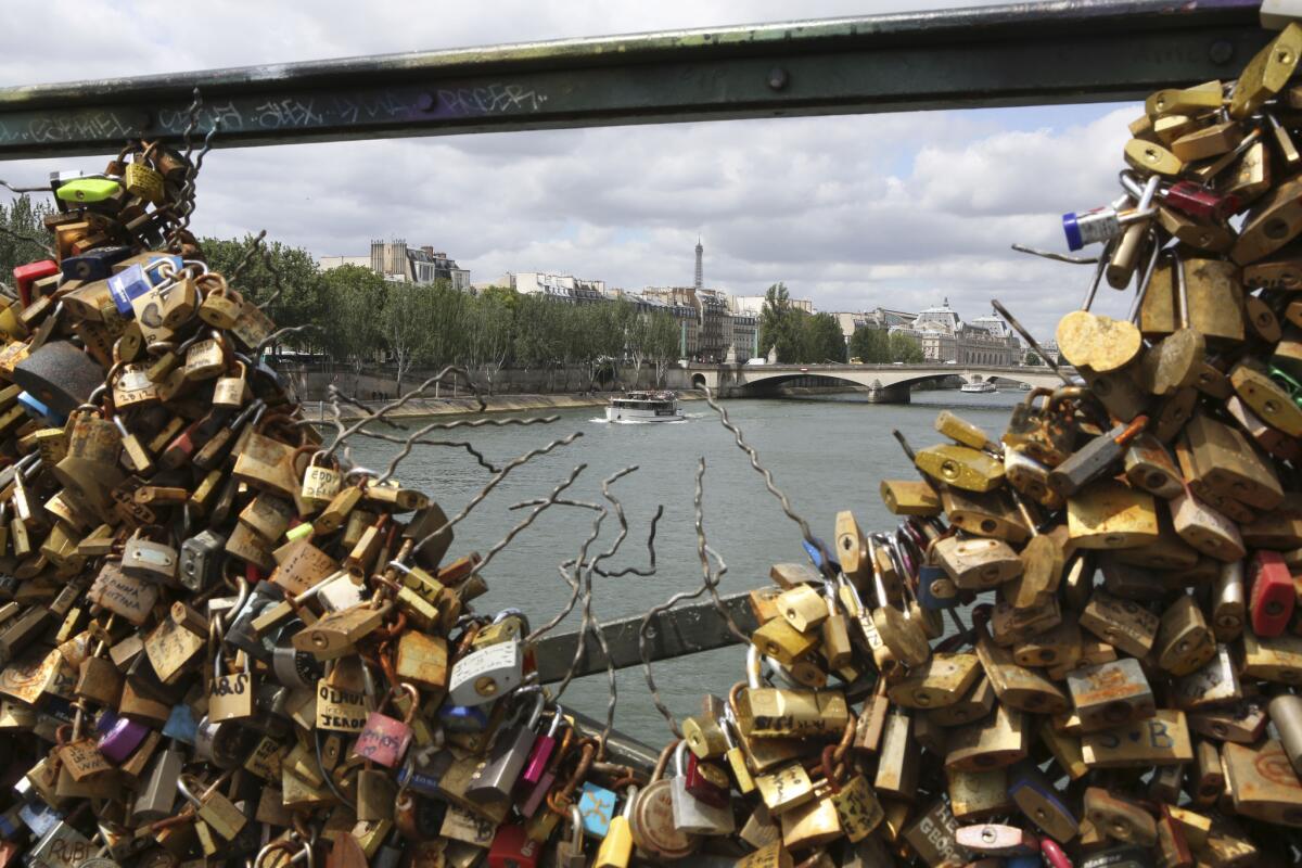 The tip of the Eiffel tower appears through a gap in lock-cluttered railing of the famed Pont des Arts bridge in Paris on June 1, 2015.