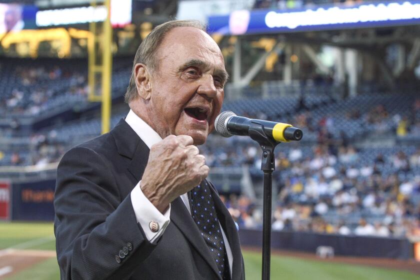 Padres television announcer Dick Enberg says "Oh my!" for the crowd during a pre game ceremony honoring the end of his sports broadcasting career.