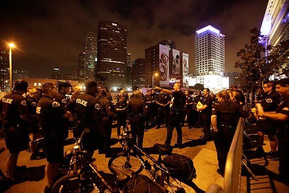 Police gather to discuss security in the pre-dawn hours on Olympic Boulevard as fans gather to pay respects to Michael Jackson at Staples Center in downtown Los Angeles.