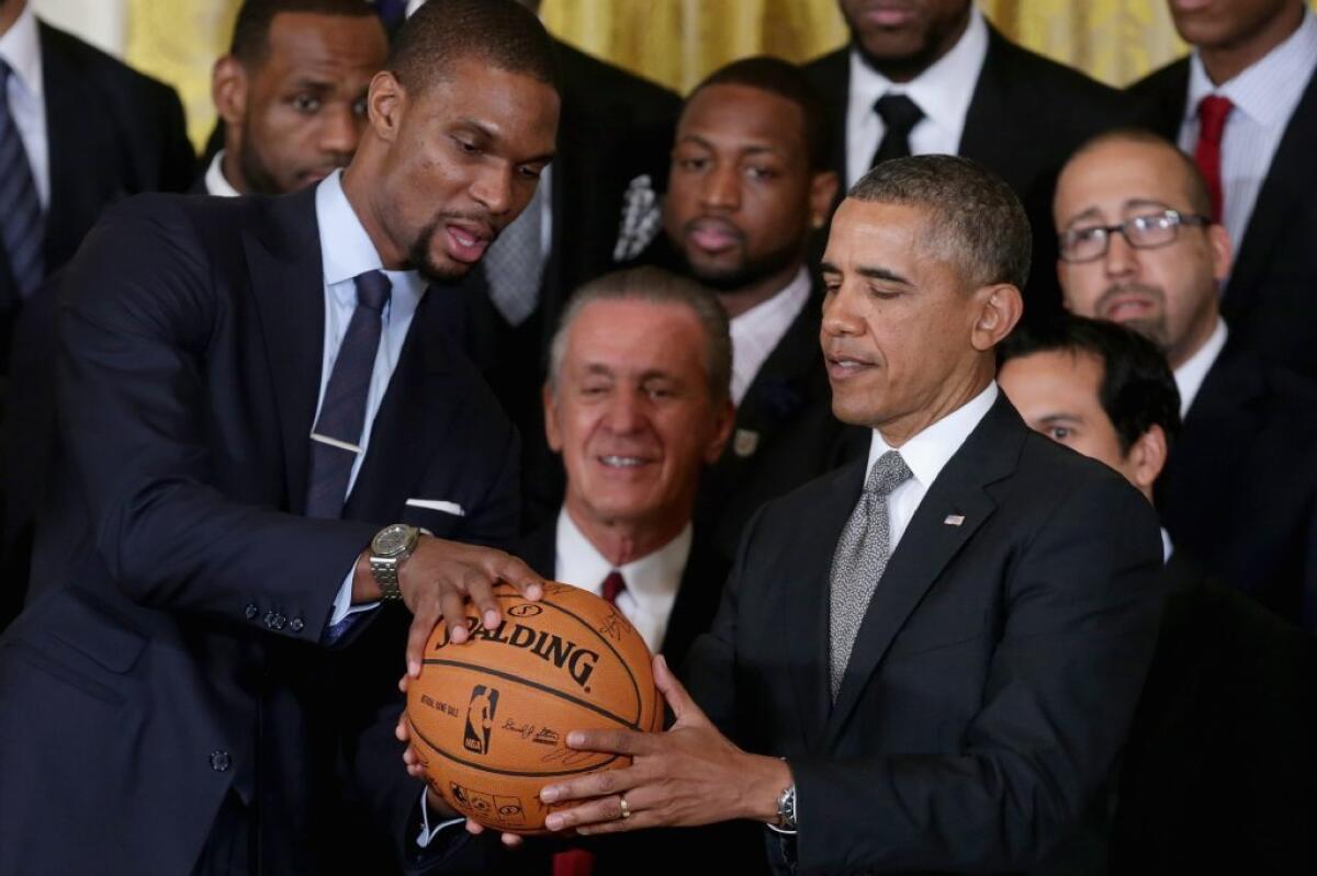 Miami Heat power forward Chris Bosh presents President Obama with a signed basketball Tuesday.