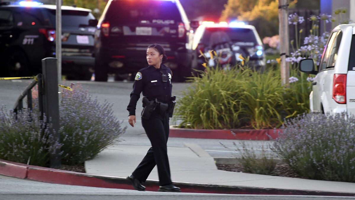 Police investigate a shooting they say left three dead at the Morgan Hill Ford dealership in Morgan Hill, Calif., on Tuesday.