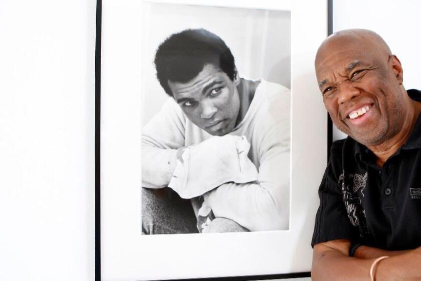 Howard Bingham, the photographer for heavyweight boxing champion Muhammad Ali, poses with one of his portraits at a Hollywood gallery in 2008.