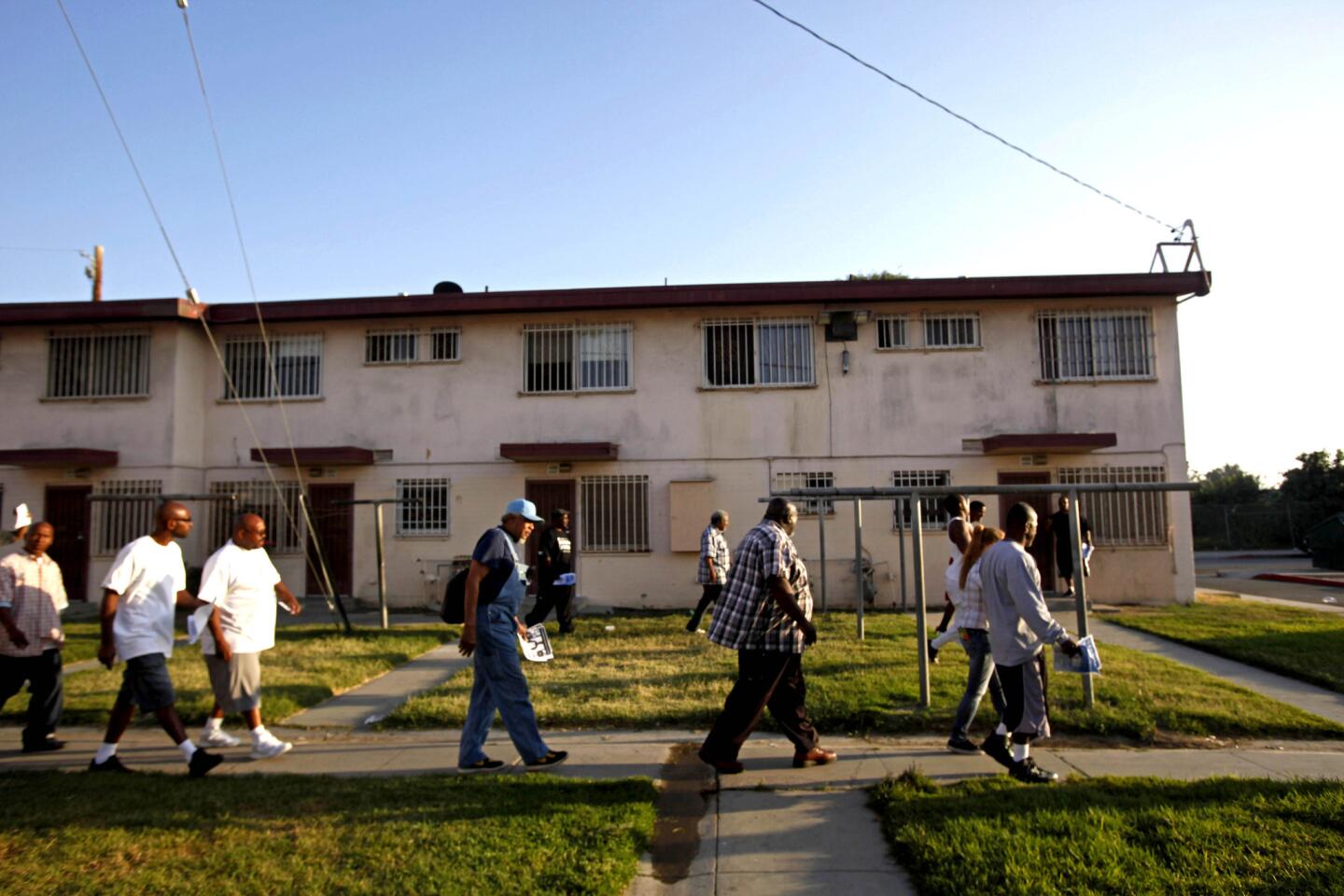 Members of Project Fatherhood walk through Jordan Downs in Watts to help spread the word about their program. The group aims to help young men avoid the mistakes of the older generation and be more responsible to their children.
