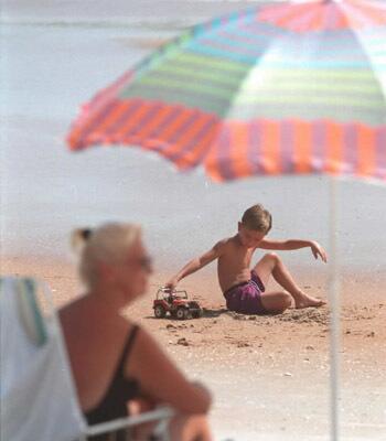 A young boy plays on the red sand during a day at Ormond Beach.