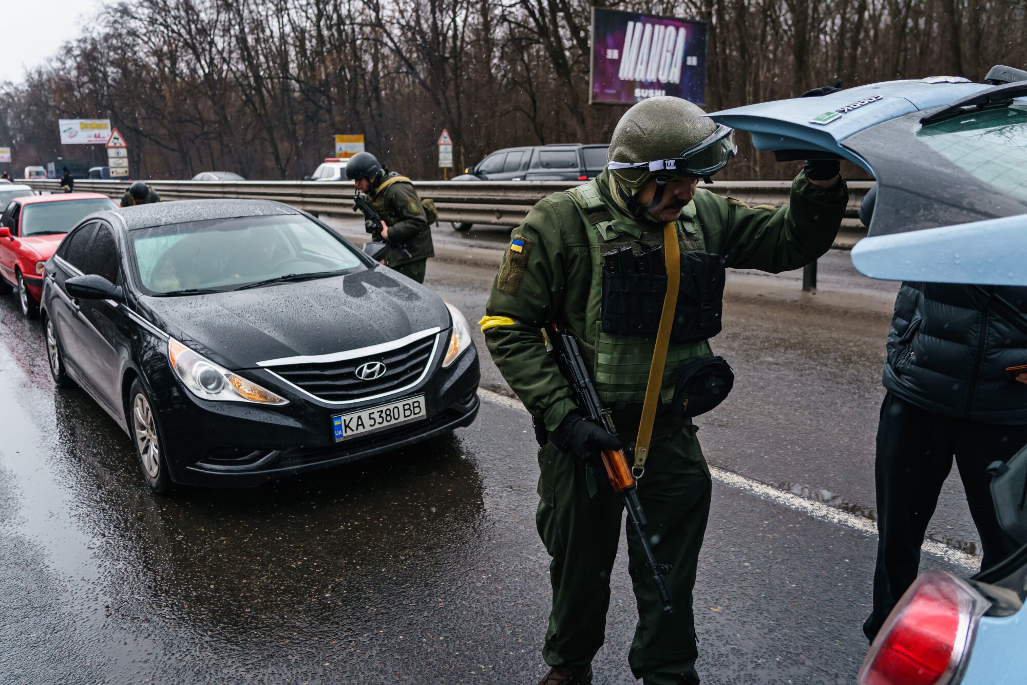 Soldiers inspect vehicles at a checkpoint on a main road entering Kyiv on Wednesday.