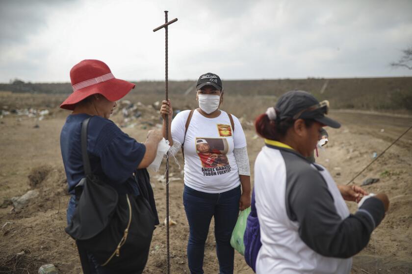 FILE - In this March 11, 2019 file photo, Lidia Lara Tobon, center, whose brother Angel Gabriel Tobon went missing, works with other relatives of the disappeared from the Solecito Collective, as they search for clandestine graves inside a municipal dump after an anonymous source sent the group a map suggesting hundreds of bodies were buried in the area, in the port city of Veracruz, Mexico. The mainly female volunteer searchers who fan out across Mexico to dig for the bodies of their murdered relatives are themselves increasingly being killed, putting to the test the government’s promise to help them in their quest for a final shred of justice: a chance to mourn. (AP Photo/Felix Marquez, File)