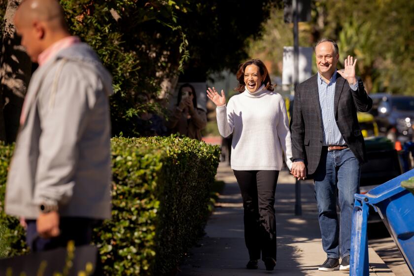 LOS ANGELES-CA- NOVEMBER 21, 2023: Vice President Kamala Harris, left, and Second Gentleman Douglas Emhoff walk through their neighborhood in Los Angeles on November 21, 2023. HOLD FOR STORY BY COURTNEY SUBRAMANIAN. (Christina House / Los Angeles Times)