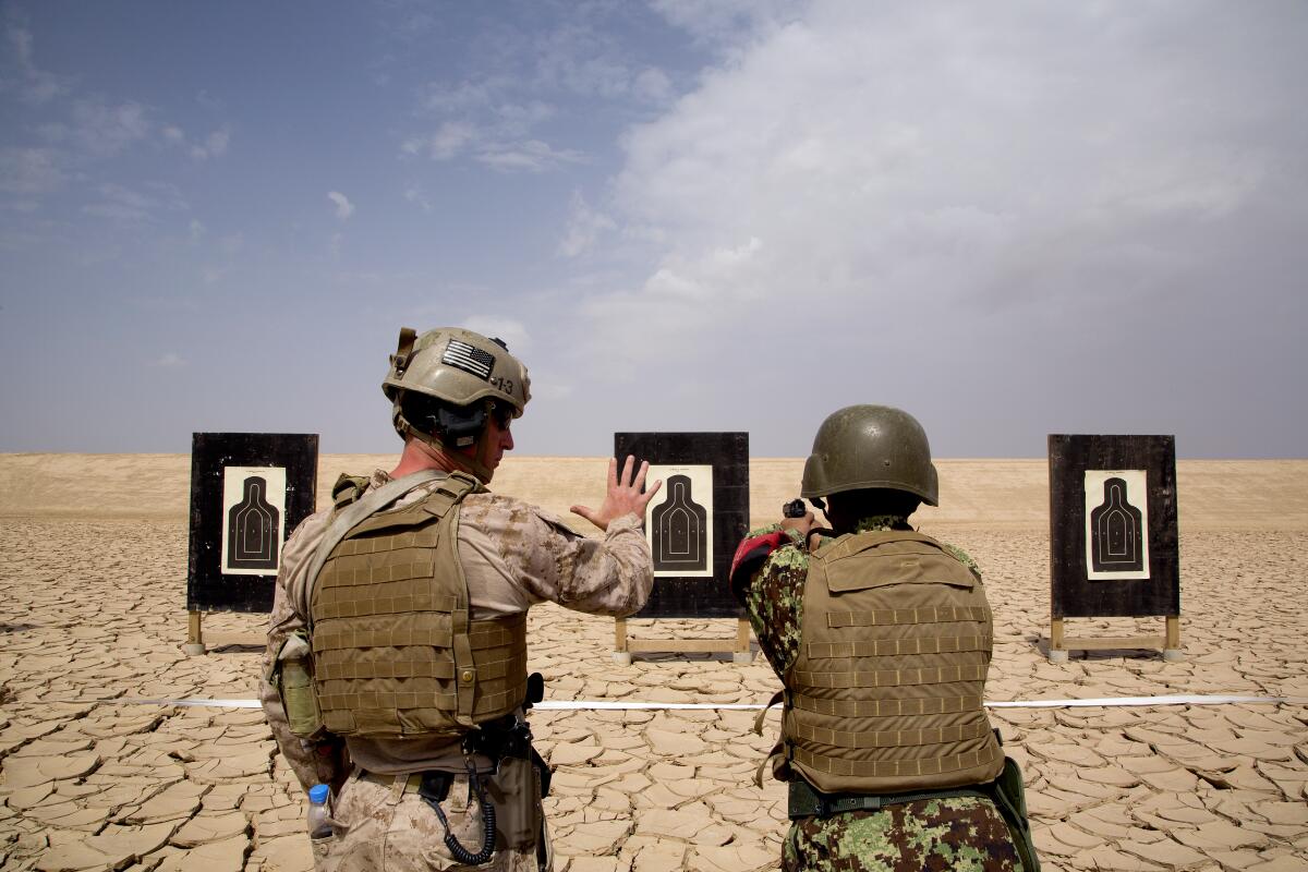 Sgt. AJ Davis, a U.S. Marine, instructs an Afghan soldier in July 2014 on marksmanship