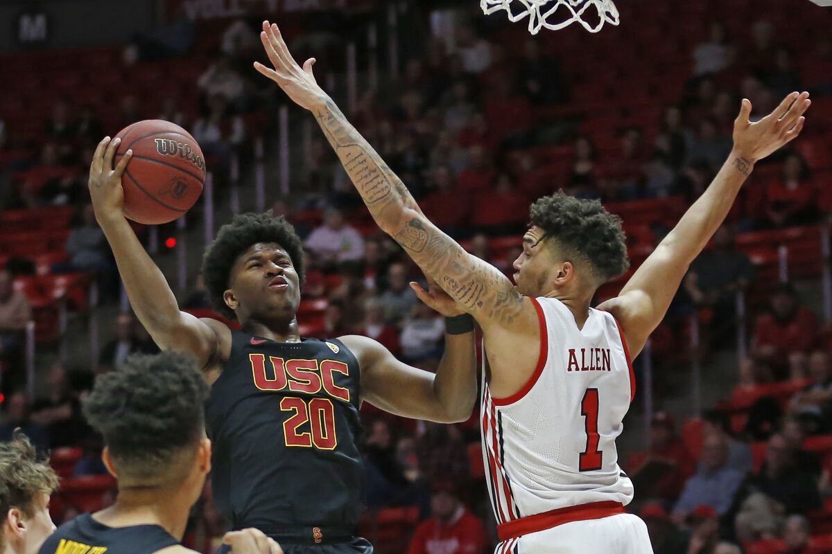 USC guard Ethan Anderson goes to the basket as Utah forward Timmy Allen defends.