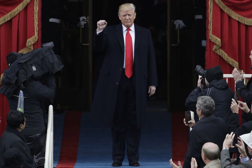 President-elect Donald Trump pumps his fist as he arrives for his presidential inauguration at the U.S. Capitol.