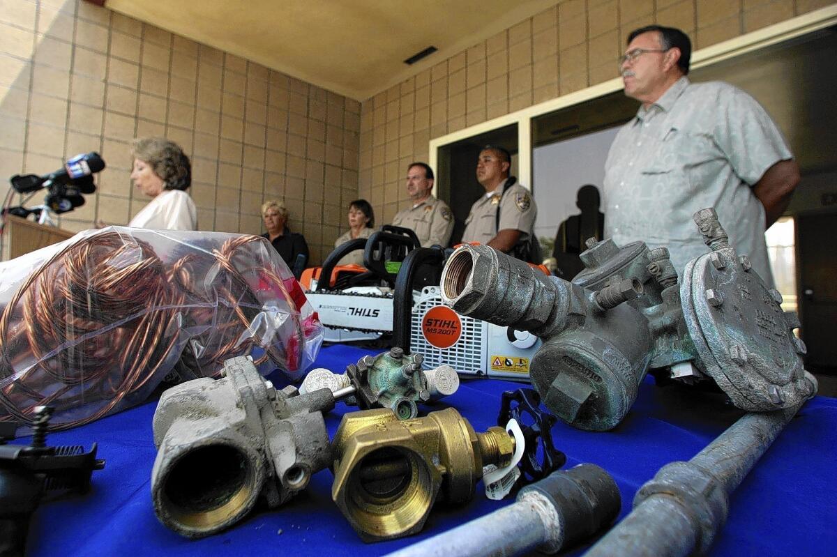 San Bernardino County Supervisor Josie Gonzales, left, speaks at a news conference seeking the public's help in stopping the theft of metal from freeways and state facilities. In the foreground are recovered stolen items. A new bill would create a task force focusing on the problem.