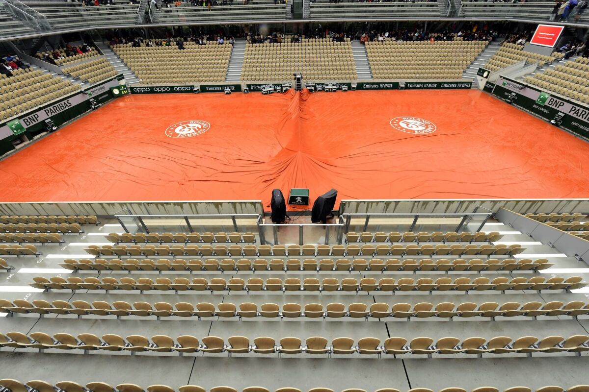 A tarp covers one of the courts at Roland Garros in Paris during a rain delay.
