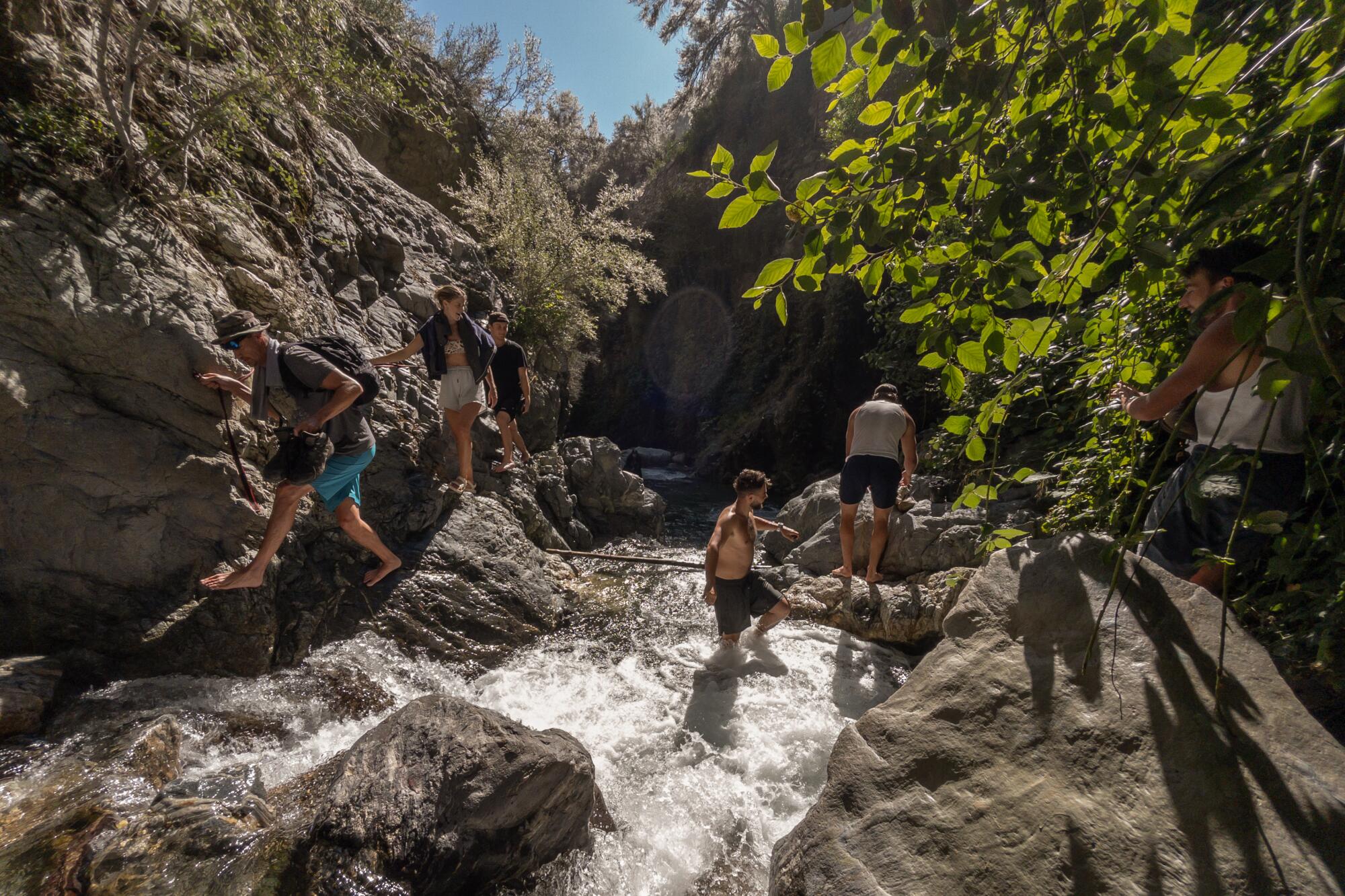 Visitors use rope guides to negotiate a section at Stoddard Canyon Falls and Slide in Mt. Baldy.