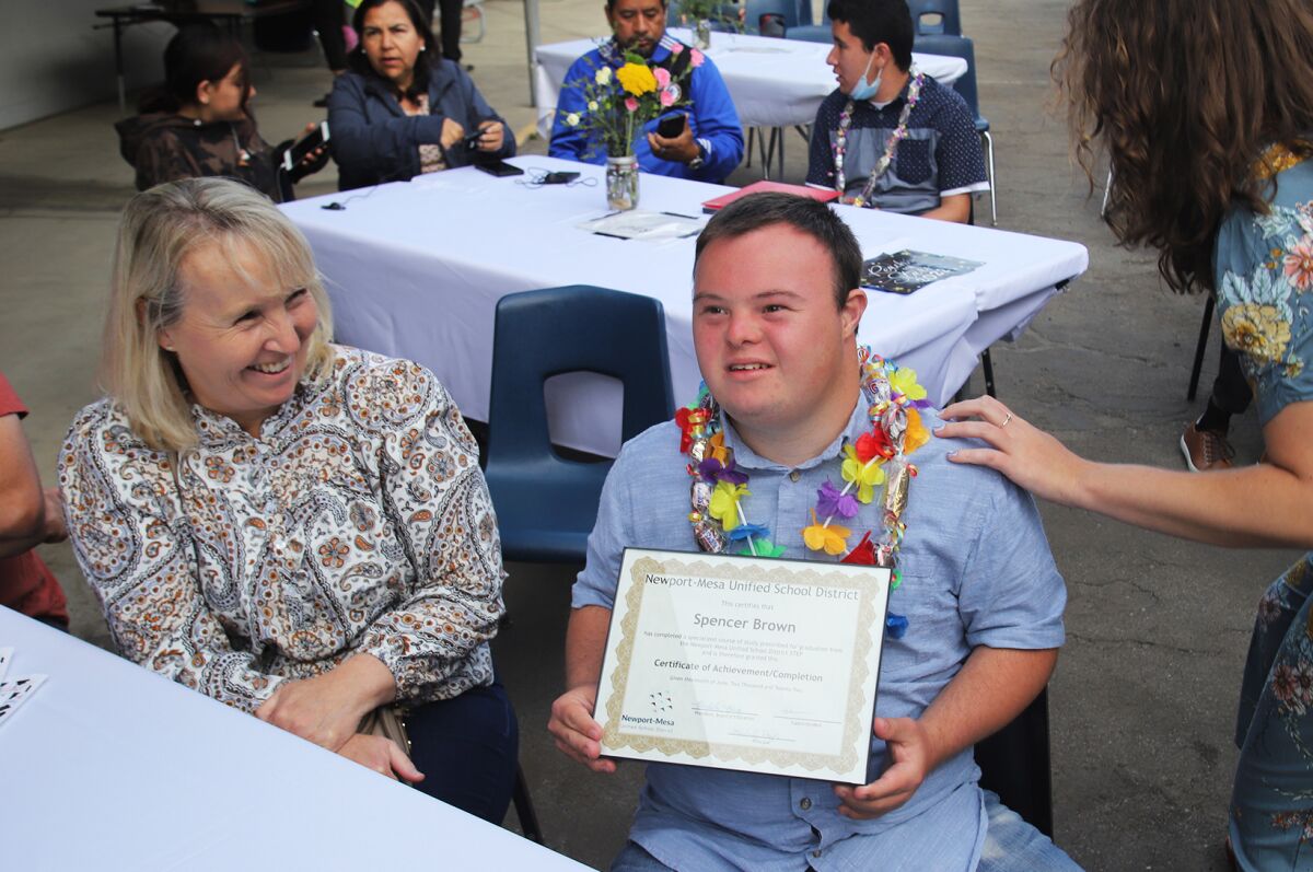Spencer Brown smiles with his diploma at Newport-Mesa Unified's STEP graduation.