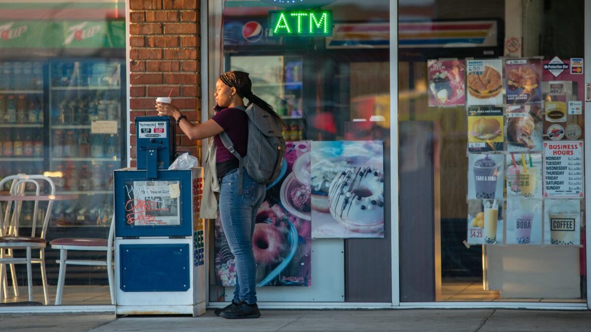 Leslie Adams has her breakfast on a Fresno Bee newspaper rack in front of Bingo Donuts in Fresno.