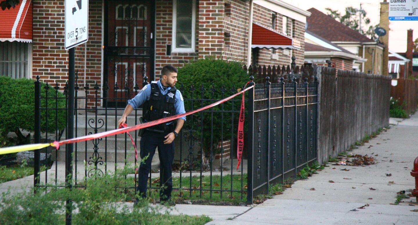 A Chicago police officer marks the area where 9-year-old Tyshawn Lee was shot to death Monday in the 8000 block of South Damen Avenue.