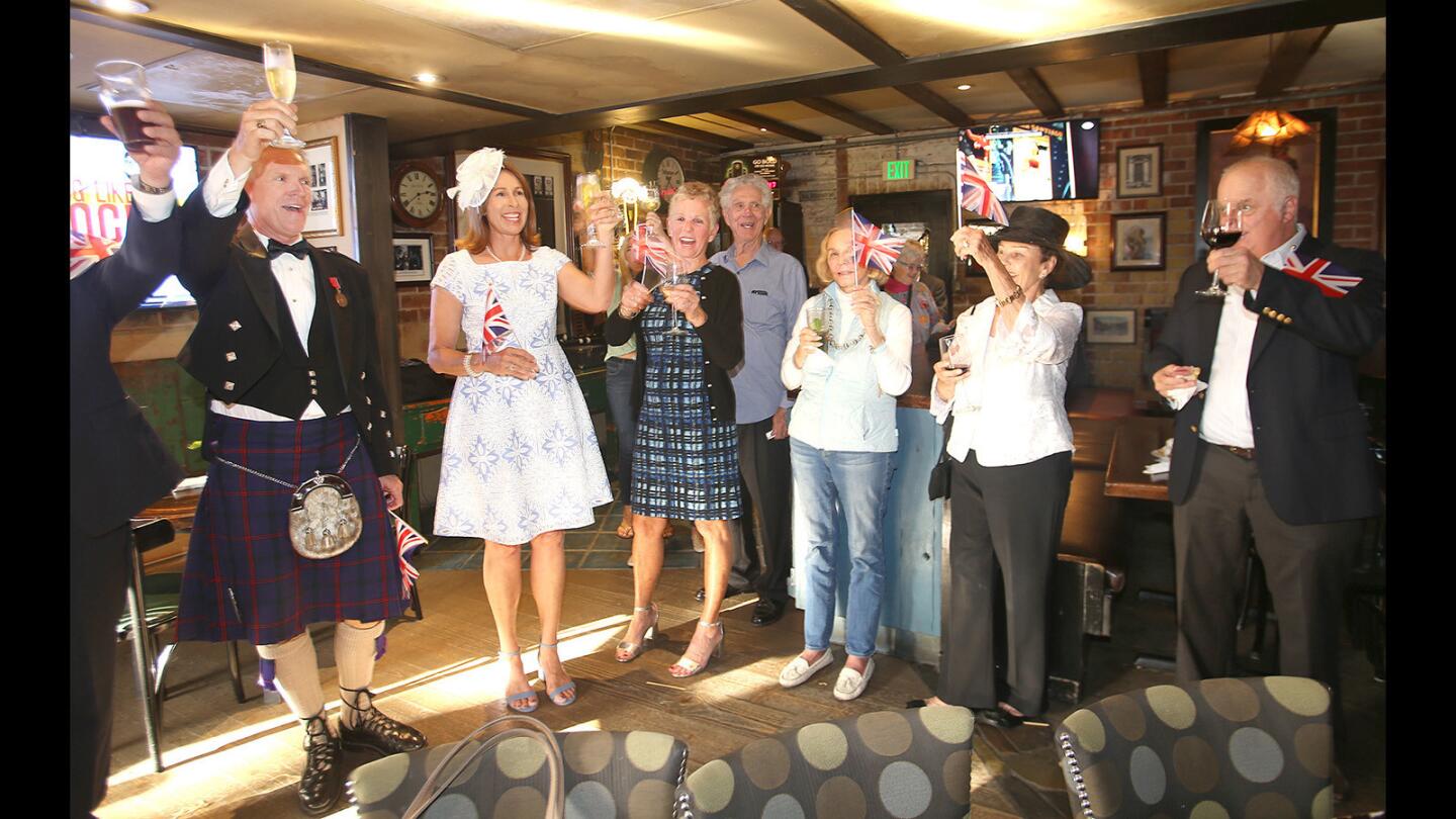 As the Union Jack waves, Michael Lawler and his wife, Barbara, at left, share a toast with members of the Celtic Bar Assn. of Orange County as they have a royal wedding-themed party at Muldoon's Irish Pub in Newport Beach on Tuesday evening.