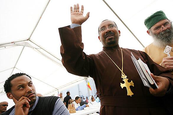 Timothy Conley, front desk coordinator of the Office of Religious Life at USC, listens as the Revs. Melaku Terefe and Thomas Finley answer questions after a church service at the Virgin Mary Ethiopian Orthodox Church on Compton Avenue.