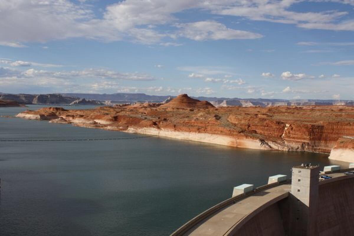 Lake Powell's "bathtub ring" of mineral salts shows the drop in water level caused by an ongoing drought in the Colorado River Basin. In the foreground is Glen Canyon Dam.