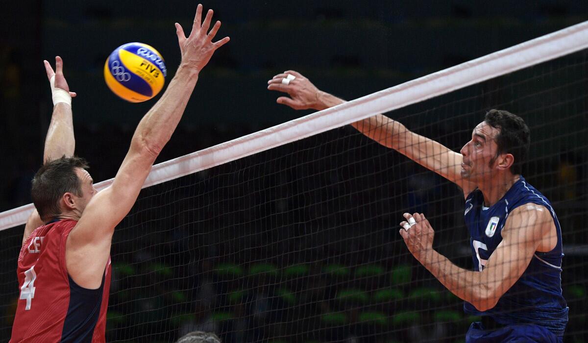 Italy's Emanuele Birarelli, right, spikes the ball while U.S. player David Lee attempts to block during a men's semifinal match Friday at the 2016 Rio Olympic Games.